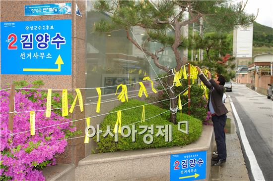 김양수 장성군수 예비후보 선거사무소측은 27일 오전 선거사무소 건물 1층 화단에 리본걸이대를 마련하고 사무소 방문자들로 하여금 자발적으로 애도와 기다림을 의미하는 노란리본을 달 수 있도록 했다.
