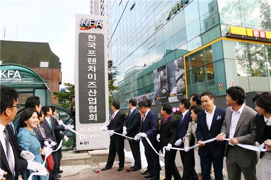 한국프랜차이즈산업협회 임직원들이 29일 서울 서초동 월헌빌딩 앞에서 현판식을 열고 있다.