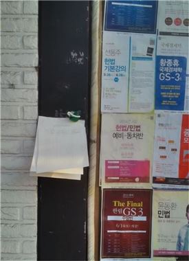 21일 서울 신림동 고시촌 학원가에 '행정고시 축소 및 폐지 반대 서명운동' 용지가 붙어있다.