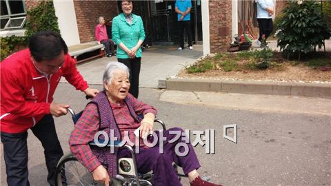 유정복 새누리당 인천시장 후보가 23일 오전 인천 사할린동포 복지관서 한 할머니의 휠체어를 밀어드리며 말을 건네고 있다. 