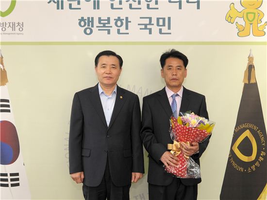 중구 소공동주민센터 김동구 주무관(오른쪽)이 남상호 소방방재청장으로부터 표창장을 받았다.