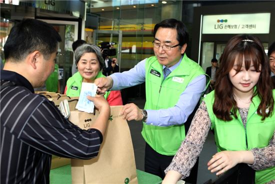 김병헌 LIG손보 사장(오른쪽 두번째)이 '2014 희망바자회'에 참석해 고객에게 기부물품을 판매하고 있다. 