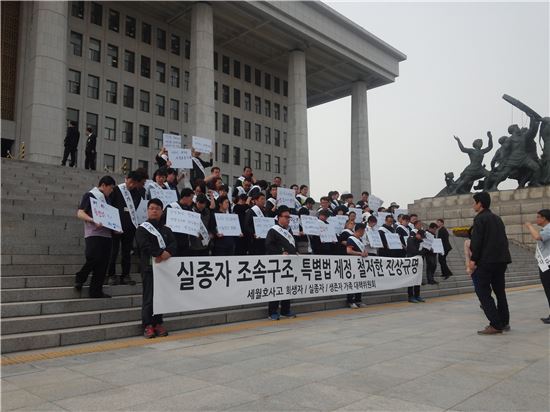 세월호 유가족들이 28일 국회 본청 앞에서 피켓을 들고 여야를 향해 국정조사 재개를 호소하고 있다.