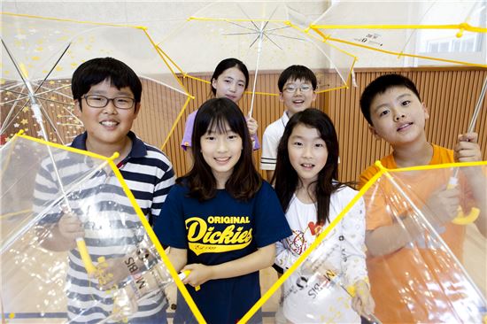 현대모비스가 어린이 교통안전을 위해 특별 제작한 투명우산을 전달받은 용인 소재 중일초등학교 학생들이 투명우산을 펼쳐 보이고 있는 모습. 