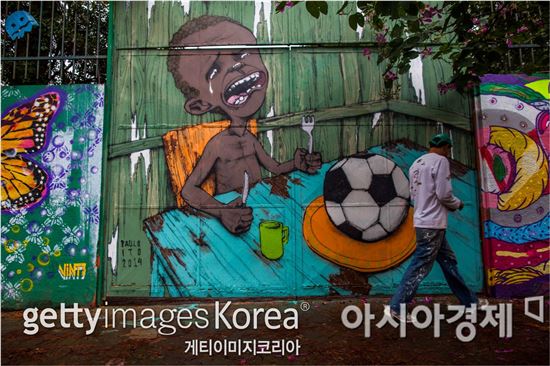 브라질 월드컵을 풍자하는 벽화[사진=Getty Images/멀티비츠]