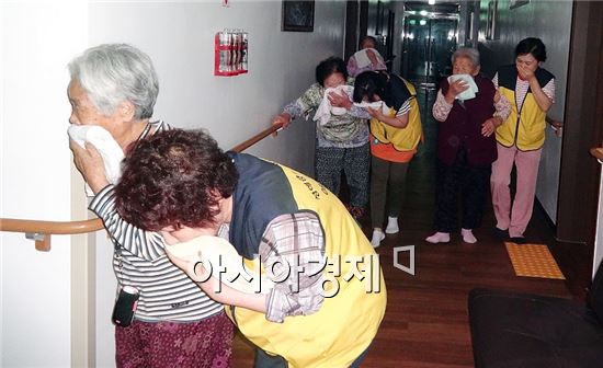 함평군 함평읍 함평성애원에서 종사자들과 노인들이 수건으로 코와 입을 막고 대피하는 야간소방훈련을 하고 있다.
