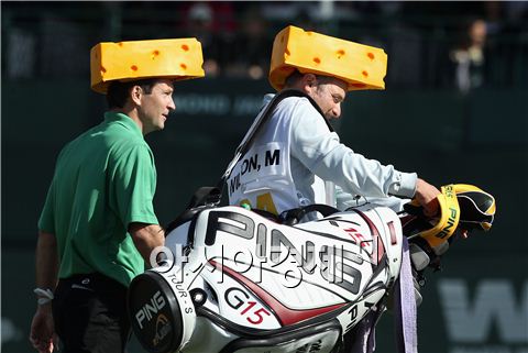 마크 윌슨(왼쪽)과 캐디 크리스 존스가 2011년 피닉스오픈에서 NFL 그린베이 패커스팀 응원단의 상징인 치즈 모자를 쓰고 경기를 하는 장면이다. 사진=Getty images/멀티비츠 
