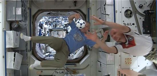 ▲무중력상태에서 미국우주비행사 와이즈먼이 공을 차고 독일우주비행사 게르스트가 이를 막고 있다.[사진제공=NASA]