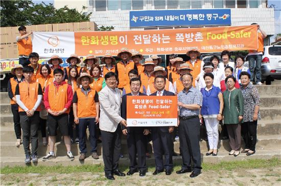 한화생명 봉사단이 대전시 중앙동에 위치한 쪽방촌 독거노인들에게 냉장고 35대를 전달하는 봉사활동을 펼친 후 기념촬영을 하고 있다. 