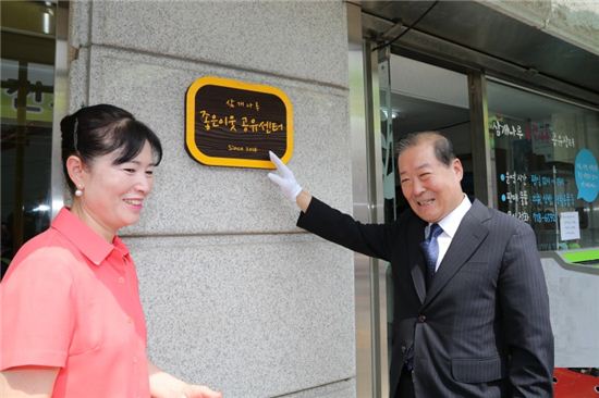 박홍섭 마포구청장(오른쪽)이 공유센터 간판을 가르치며 의미를 부여하고 있다.