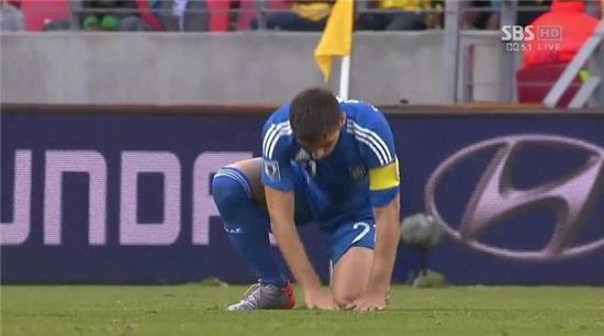 ▲지난 2010년 월드컵 한국-그리스전에서 카추라니스는 파헤쳐진 잔디를 다듬는 '매너'를 보여줬다. 이에 그는 '잔디남'이라는 별명을 얻었다. (사진: SBS 중계화면 캡처)