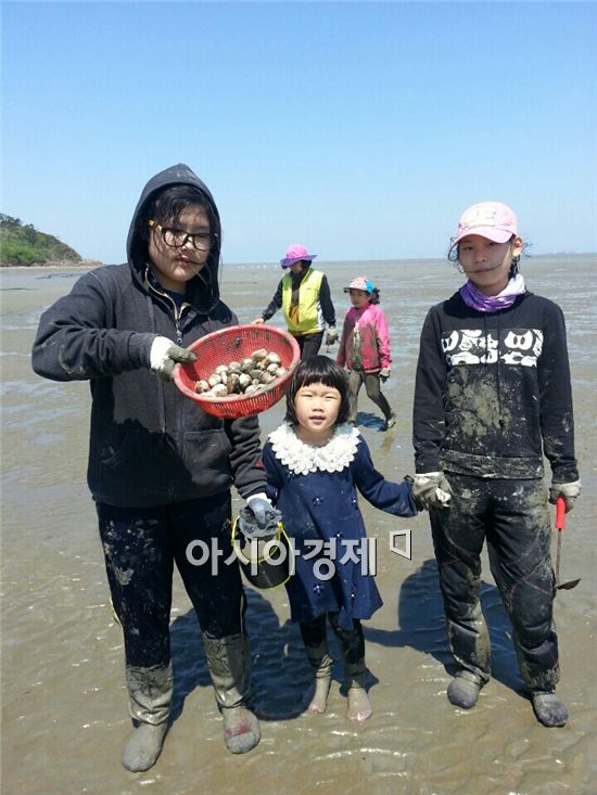 영광 백수해안도로 인근 바닷가에서 가족들이 해산물을 잡고 포즈를 취하고 있다.