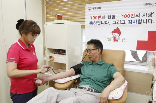 헌혈 100회를 맞은 청주시청 회계과 이기홍(오른쪽) 담당이 피를 뽑고 있다.