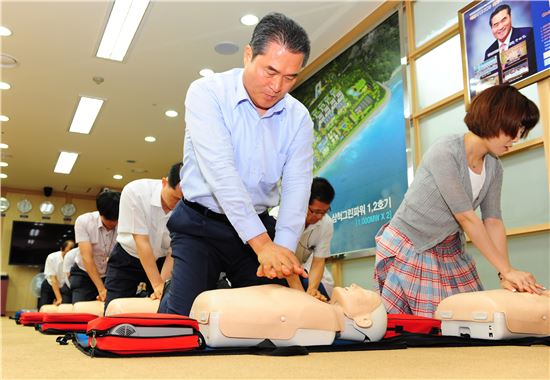 이상호 한국남부발전 사장과 직원들이 심폐소생술 모형(애니)으로 흉부압박법을 실습하고 있다.