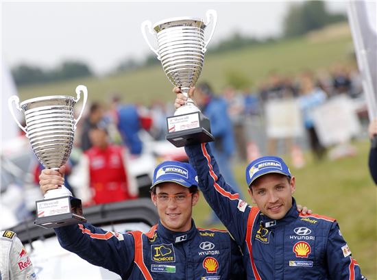 지난달 열린 2014 WRC 7차 폴란드랠리에서 현대차 월드랠리팀 소속 티에리 누빌(왼쪽) 선수와 보조 드라이버인 니콜라스 질솔 선수가 3위 트로피를 들고 기념촬영하고 있다.
