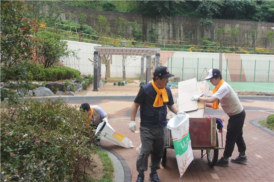 김치현 롯데건설 대표이사(사진 가운데)가 아파트 단지 청소를 하고 있다.
