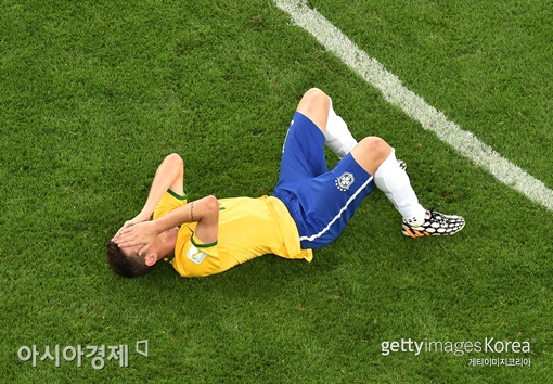 브라질 공격수 오스카르가 독일과의 준결승전에서 1-7로 패한 뒤 그라운드에 쓰러져 얼굴을 감싸고 있다. [사진=Getty Images/멀티비츠]
