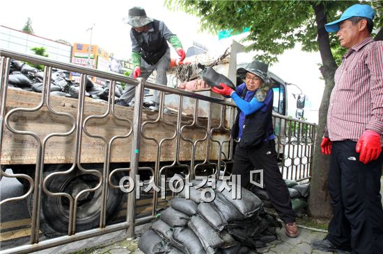 본격적인 장마철을 맞아 9일 광주 북구청 건설과 직원들이 폭우로 인한 침수 피해를 미연에 방지하기 위해 운암동 상습침수지역인 상가 인근에 모래주머니를 쌓고 있다. 사진제공=광주시 북구

