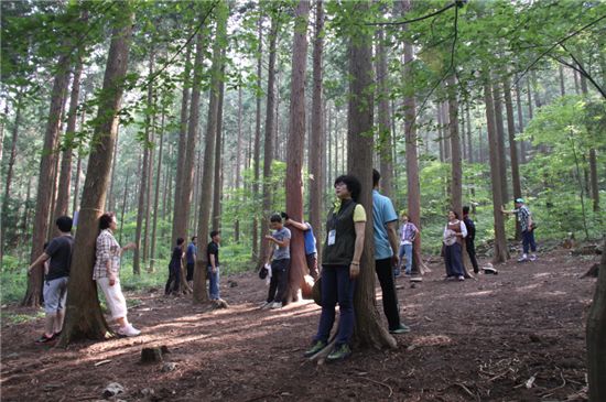 AI방역담당공무원들이 나무에 기대어 산림치유를 받고 있다.