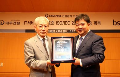 이훈복 대우건설 경영지원실장과 BSI Korea 천정기 회장이 ISO/IEC 20000 인증패를 들고 기념촬영을 하고 있다.