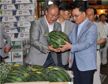 정홍원 총리가 지난 12일 송파구 가락시장의 한 상점을 방문, 수박을 들어보이고 있다.