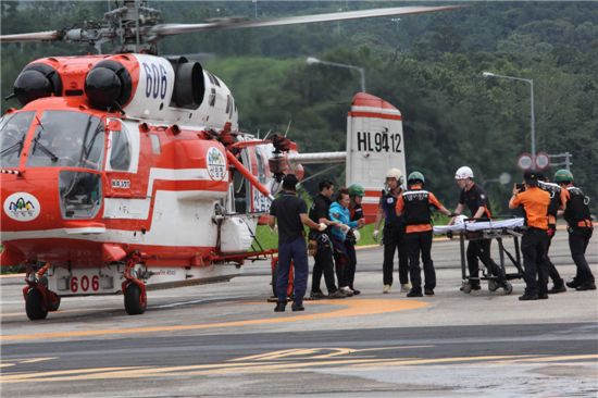 경남 밀양 가지산을 오르다 다친 50대 여성환자를 산림헬기로 구조, 병원으로 옮기고 있는 양산산림항공관리소 직원들