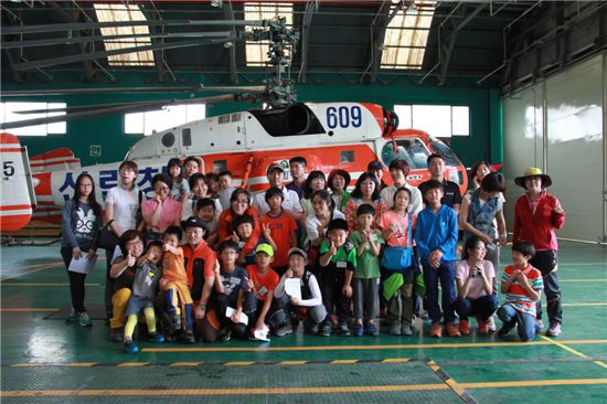 산림청헬기 체험행사 참가자들이 산림헬기를 배경으로 기념사진을 찍고 있다.