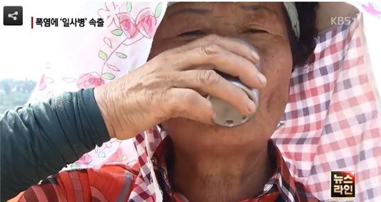 때이른 폭염에 지친 할머니가 물을 마시고 있다.(사진:KBS 1TV '뉴스라인' 방송 캡처)