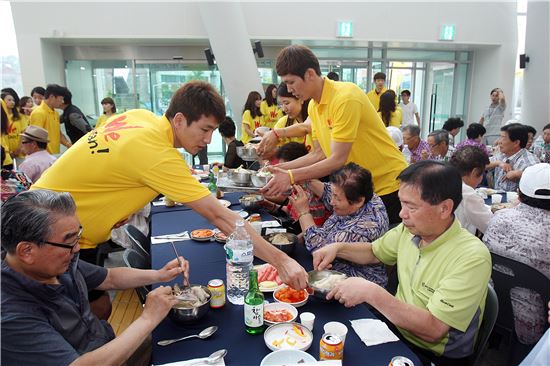 OK저축은행 배구단 주장 강영준 선수(왼쪽)와 김규민 선수가 어르신들의 식사를 돕고 있다. 