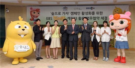 김용하(왼쪽에서 6번째) 산림청 차장과 윤문상(5번째) 한국교육방송공사 부사장 등 두 기관 관계자들이 '두다다쿵' 캐릭터와 함께 기념사진을 찍고 있다. 
 