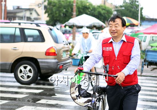 이정현 새누리당 후보가 자전거를 타고 다니면서 선거운동을 하고있다.