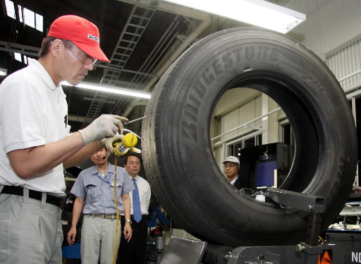 브리지스톤 작업장에서 작업자가 재생 타이어를 검사하고 있다. 사진=블룸버그