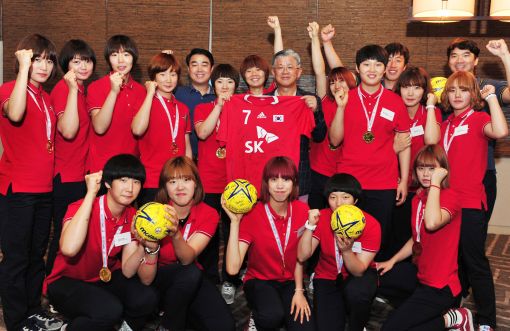 최신원 SKC 회장(가운데)이 26일 여자 핸드볼 주니어 선수단을 초청해 만찬을 함께 한 뒤 유니폼을 전달하고 있다.