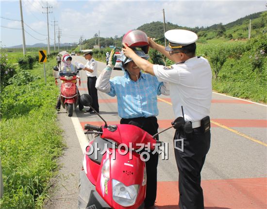 함평경찰관들이 주민들을 상대로  올바른 이륜차 안전모 착용을  홍보하고 있다.