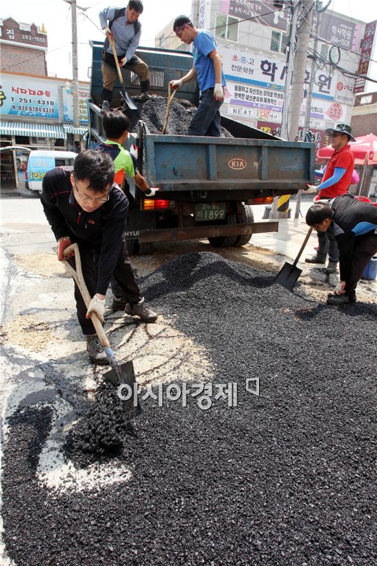 최근 광주 지역의 집중 폭우로 인해 도로 곳곳이 패이는 포트홀 현상이 발생해 운전자들과 보행자들이 통행에 많은 불편을 겪고 있는 가운데 30일 광주 북구 건설과 도로팀 직원들이 오치동의 한 이면도로에서 도로 긴급보수 작업을 하고 있다.  사진제공=광주시 북구

