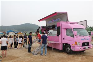 배스킨라빈스 핑크카를 찾은 아이들이 아이스크림을 먹으며 즐거워하고 있다.
