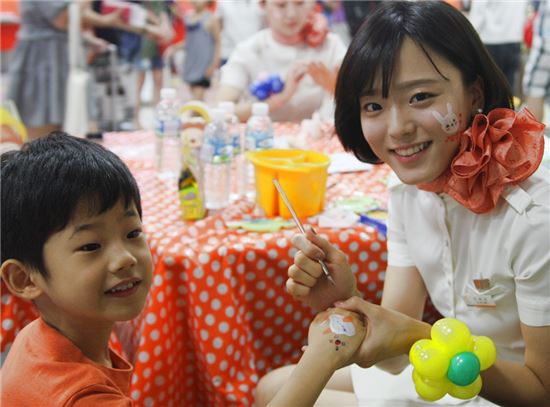 제주항공 특화서비스팀 승무원이 광복절을 맞아 김포공항 제주항공 카운터 앞에서 어린이들에게 태극기를 그려주고 있다.