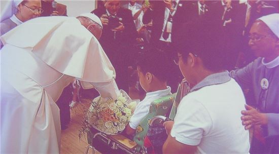 16일 오후 꽃동네를 방문한 프란치스코 교황이 이곳에서 생활하는 화동으로부터 꽃다발을 전달받고 있다. 