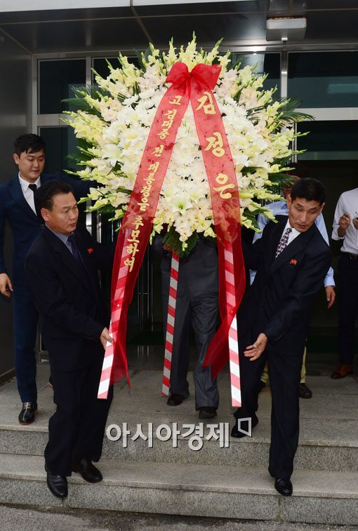 북한이 17일 개성에서 김대중 대통령 서거 5주년을 기념하는 조화를 박지원 의원 등에게 전달하고 있다.사진=통일부 공동취재단