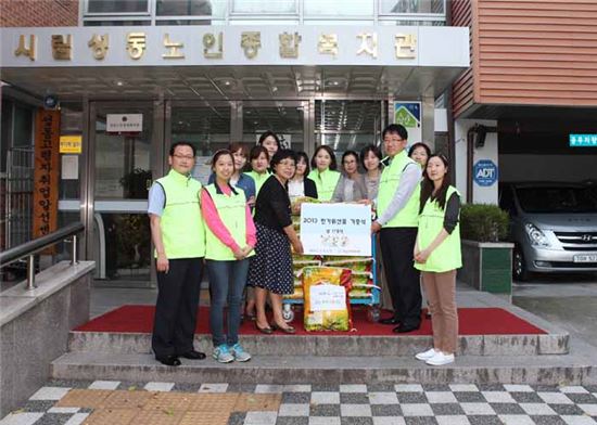 지난 2013년 추석사랑나눔 활동으로 완주군장애인복지관을 찾은 외환은행 전주공단지점 직원들이 'KEB 사랑미(米)' 등 생필품 전달 후 복지관 관계자들과 기념사진 촬영을 하고 있다.(자료제공:외환은행)