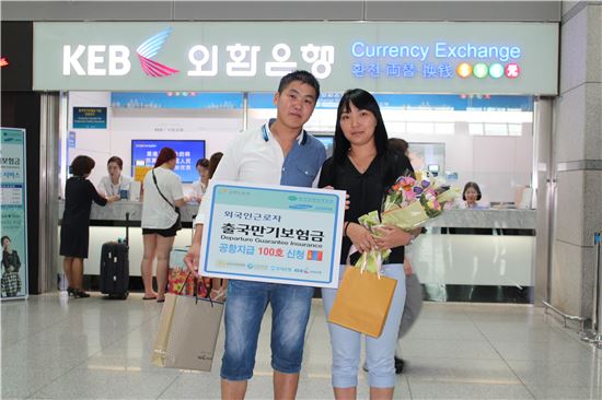 외국인근로자 출국만기보험금 공항지급 100번째를 기념해 몽골 출신의 에르데네바타씨(왼쪽)가 아내와 함께 기념촬영을 하고 있다.
