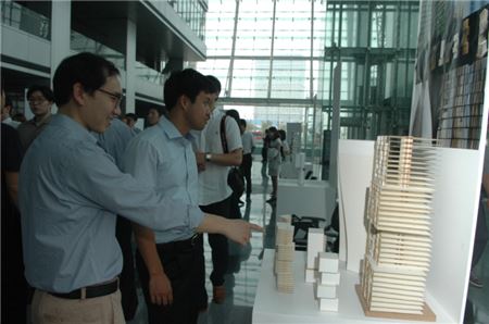 포스코건설 22일 인천 송도 사옥에서 영국 건축명문대학인 AA와 공동으로 송도국제업무단지 건축물 디자인 연구성과 발표회를 가졌다. 포스코건설 직원들이 전시물을 관람하고 있다.