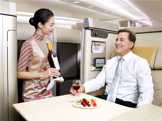 아시아나항공 승무원이 일등석에서 와인 서비스를 하고 있다. 