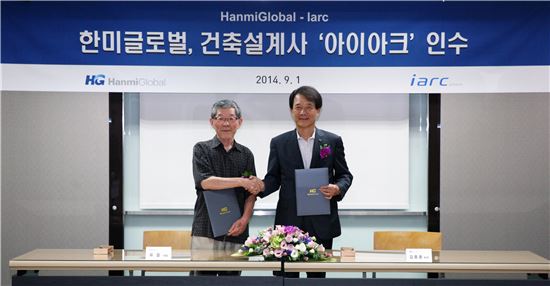 ▲유걸 아이아크 대표(왼쪽)와 김종훈 한미글로벌 회장(오른쪽)이 나란히 서서 악수를 하고 있다. 한미글로벌은 '비전 2020' 달성을 위해 건축 설계업체인 아이아크를 인수했다고 2일 밝혔다.