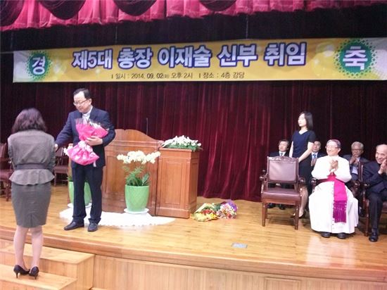 <이재술 목포가톨릭대 총장이 2일 취임식에서 축하 꽃다발을 받고 있다.>
