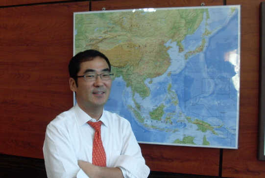▲최재우 KB국민은행 캄보디아 법인장이 세계지도를 배경으로 포즈를 취하고 있다.