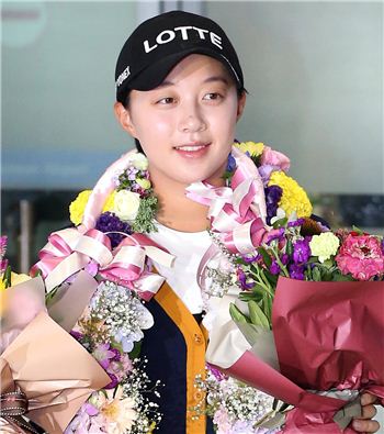 김효주가 인천공항으로 입국해 꽃다발을 받아들고 포즈를 취하고 있다.