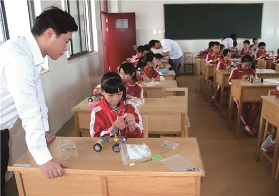 현대모비스 직원들과 중국 옌청공학대학 재학생들이 옌청 제3초등학교에서 5학년 학생들을 대상으로 태양광 자동차 만들기 수업을 진행하고 있는 모습. 