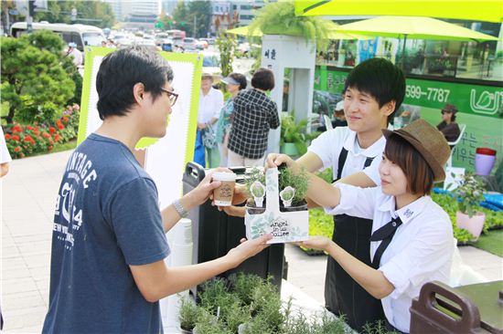 롯데리아와 엔제리너스커피가 지난 23일 서울시 도시 농업 박람회에서 커피박으로 생산한 커피 퇴비와 화분을 참가자들에게 무료로 증정하고 있다.
