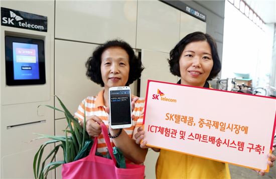 SK텔레콤 관계자들이 29일 서울 중곡 제일시장에 구축된 ICT체험관 및 스마트배송시스템을 선보이고 있다.